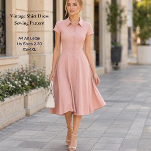 Op de afbeelding: Een lichtroze vintage overhemdjurk met korte mouwen en een knoopsluiting aan de voorkant. De jurk heeft een kraag en een uitlopende rok. Tekst op de afbeelding luidt "Vintage Shirt Dress Sewing Pattern" en maatdetails.