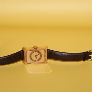 May include: A set of three ceramic mugs with a speckled, matte finish. The mugs are in shades of cream, light gray, and dark gray. Each mug has a simple, minimalist design and a rounded handle.