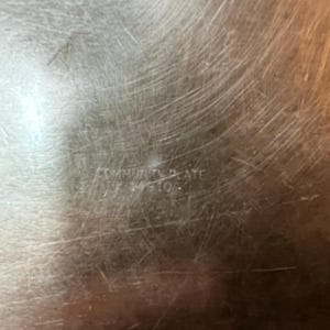 May include: Close-up of a silver serving tray with the words "Community Plate" engraved on the bottom.