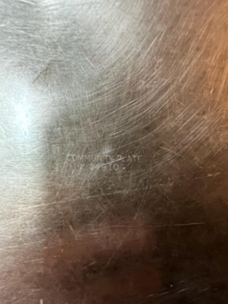 May include: Close-up of a silver serving tray with the words "Community Plate" engraved on the bottom.