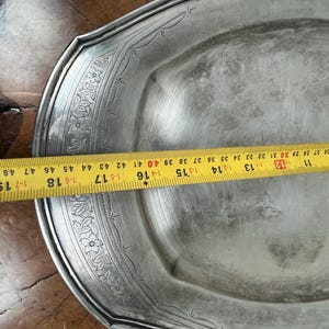 May include: A silver serving platter with a decorative floral design around the edge. The platter is 16 inches in diameter.