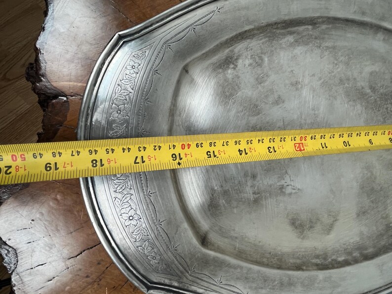 May include: A silver serving platter with a decorative floral design around the edge. The platter is 16 inches in diameter.