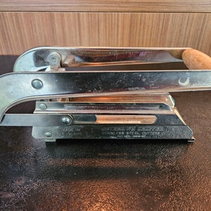 May include: A silver and wood chip cutter with the text "Southern Chip Shop Stainless Steel Cutters Pat. Appl. 13829-87" and "Made in England" on the side.