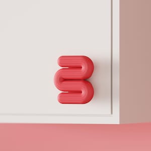 Può includere: Una scultura astratta rosso vivo a forma di lettera "S" su uno sfondo bianco e rosa. La scultura ha una superficie strutturata e un design arrotondato e fluido. L'estetica generale è moderna e minimalista.