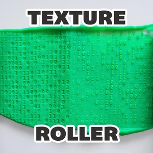May include: A green, textured material with a binary code pattern is shown between two red texture rollers. The word "TEXTURE" is above the material, and "ROLLER" is below it, in bold, black text.