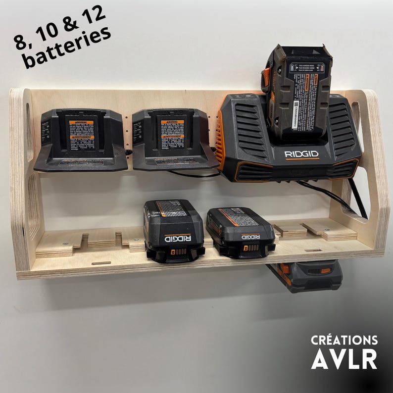 May include: A wooden battery organizer with multiple black and orange power tool batteries and chargers. The organizer has slots for 8, 10, and 12 batteries. The brand name "RIDGID" is visible on the chargers.