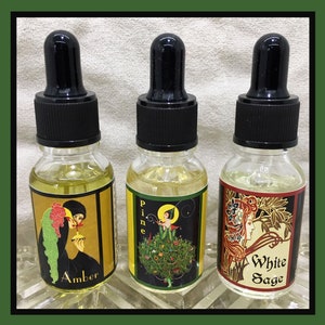 May include: Three glass bottles with black caps and labels. The labels feature illustrations of women and text that reads "Amber", "Pine", and "White Sage".