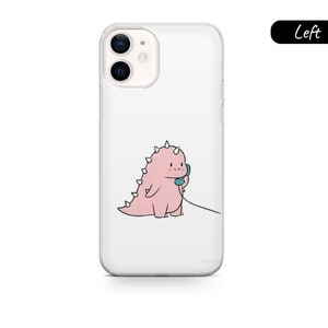 May include: Clear phone case featuring a cartoon pink dinosaur holding a blue telephone receiver. The dinosaur has spiky protrusions along its back. The phone case is designed for a smartphone.