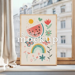 May include: A framed print with a colorful illustration of a watermelon slice, a rainbow, butterflies, and flowers. The text "FRAME MOCKUP" is printed on the image.