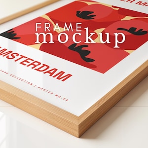 以下が含まれることがあります： 木製のフレームのモックアップで、ポスターが入っています。ポスターには、赤、黄、黒の抽象的なデザインと、「AMSTERDAM」と「FRAME mockup」のテキストが書かれています。