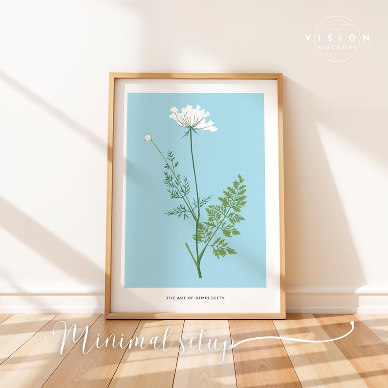 May include: A framed print of a white flower with green leaves on a light blue background. The frame is light brown wood. The text "The Art of Simplicity" is at the bottom of the print.