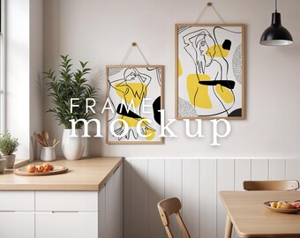 May include: Two framed art prints with abstract line art in yellow, black, and white hang on a wall. The frames are light wood, suspended by twine. The text "FRAME mockup" is overlaid on the image. The scene includes a kitchen with a wooden countertop and white cabinets.