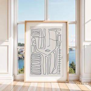May include: A black and white line art print of an abstract face with geometric shapes. The print is framed in a light wood frame and is hanging on a wall.