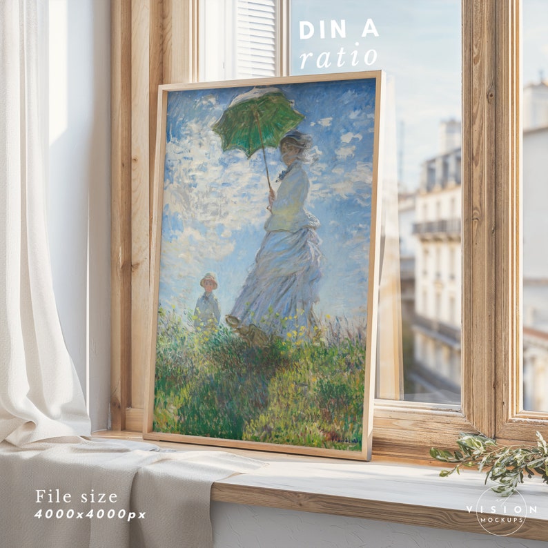 May include: A framed painting of a woman in a white dress holding a green umbrella, standing in a field of flowers with a child in the background. The painting is in a wooden frame and is hanging on a wall.
