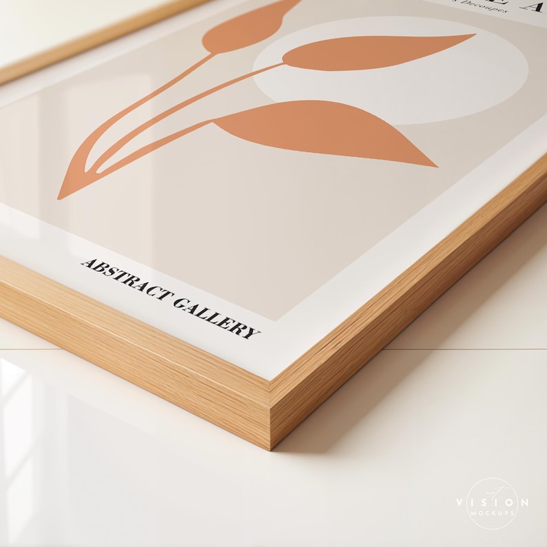 May include: A framed print with a minimalist abstract design featuring a light brown flower with a white circle in the background. The frame is made of natural wood and the print has the text "ABSTRACT GALLERY" at the bottom.