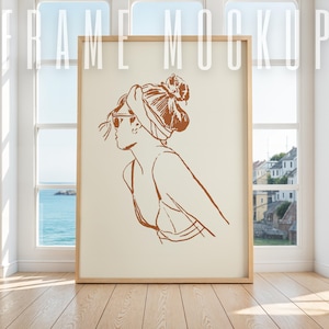 May include: A framed illustration of a woman with a headscarf and sunglasses. The illustration is in brown tones on a cream background.