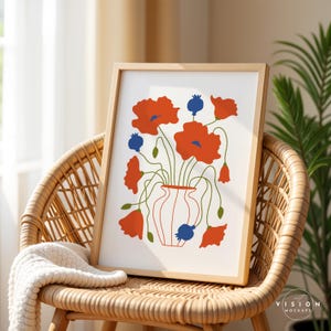 Pode incluir: Uma impress&atilde;o emoldurada de uma ilustra&ccedil;&atilde;o estilizada de um vaso cheio de flores de papoula vermelhas. O vaso &eacute; branco com uma borda vermelha e as flores t&ecirc;m centros azuis. A impress&atilde;o est&aacute; sobre um fundo branco e tem uma moldura de madeira.