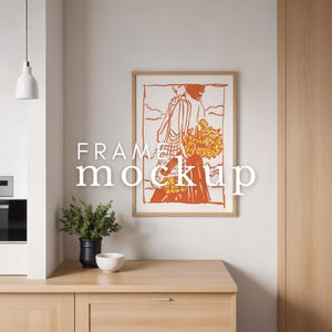 Könnte beinhalten: Eine gerahmte Illustration einer Person, die einen Blumenkorb hält. Die Illustration ist in Orange- und Rottönen vor einem weißen Hintergrund mit Wolken. Der Rahmen ist in hellem Holzton. Das Bild hängt an einer weißen Wand in einer Küchenumgebung.