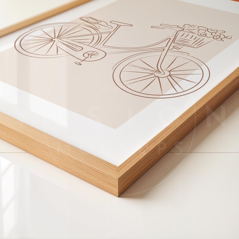 May include: A framed print of a line drawing of a bicycle with a basket of flowers on the handlebars. The bicycle is brown and the background is a light beige color.
