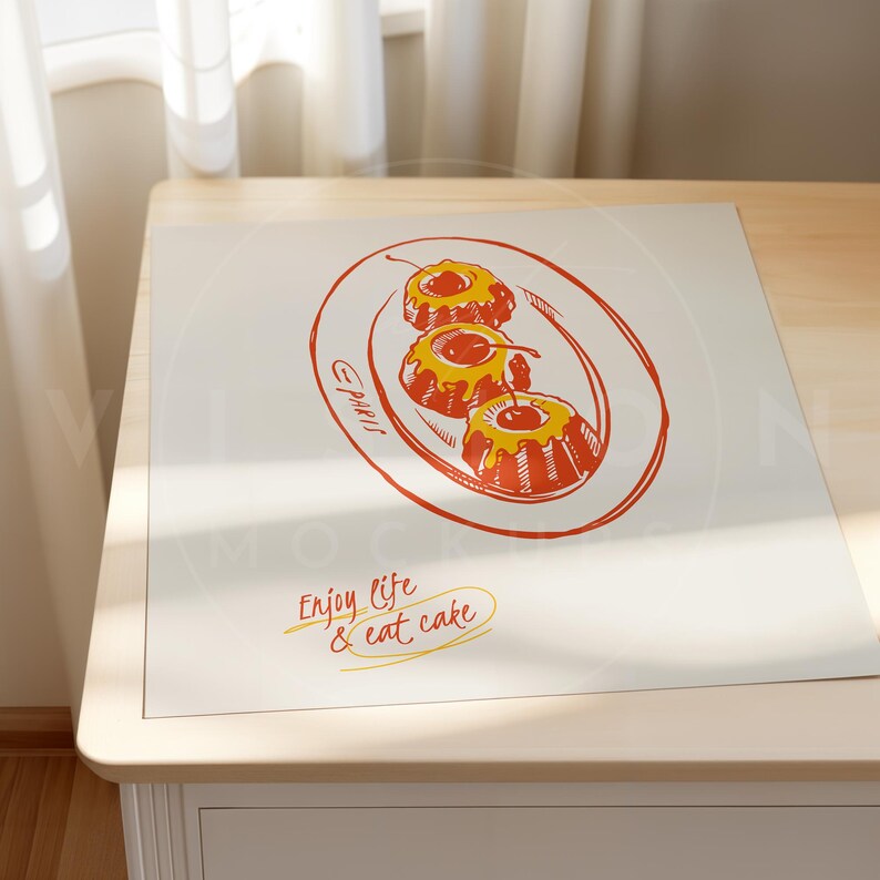 K&ouml;nnte beinhalten: Ein wei&szlig;er Platzdeckchen mit einer handgezeichneten Illustration von drei gelben und roten Gugelhupfkuchen mit Kirschen darauf. Das Platzdeckchen tr&auml;gt den Text "Enjoy life & eat cake" in Orange.
