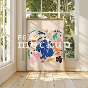 May include: A framed print with a colourful abstract design featuring a blue figure sitting with legs crossed. The design includes a variety of shapes, including stars, moons, and flowers. The frame is a light brown wood.