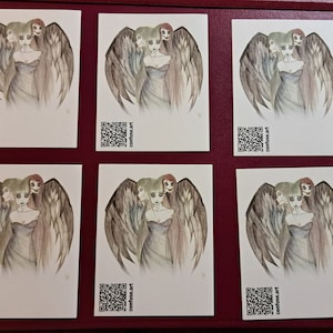 Könnte beinhalten: Fünf weiße Karten mit einer Schwarzweißillustration einer Frau mit drei Köpfen und Flügeln. Die Frau trägt ein langes, dunkles Kleid. Jede Karte hat einen QR-Code und den Text "comtesse.art" unten gedruckt.
