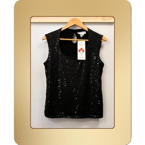 May include: Black sequin sleeveless top with a scoop neckline, hanging on a wooden hanger. The top is displayed against a white backdrop. A tag with a maple leaf logo is attached.