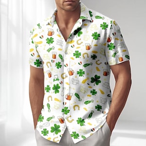 May include: White short-sleeved shirt featuring a pattern of green shamrocks, beer mugs, horseshoes, and other St. Patrick's Day themed graphics. The shirt has a button-down collar and is made of a lightweight fabric.