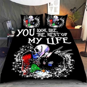 Puede incluir: Juego de cama negro con un diseño de pareja de esqueletos y el texto "YOU LOOK LIKE THE REST OF MY LIFE". El juego incluye una funda nórdica y dos fundas de almohada. El diseño incorpora acentos rojos, azules y verdes.