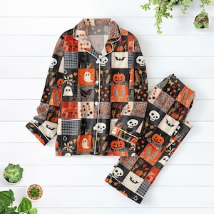 Könnte beinhalten: Ein Halloween-Pyjama-Set mit einem Hemd zum Knöpfen und einer passenden Hose. Das Set ist mit einem Patchwork-Design aus Kürbissen, Geistern, Fledermäusen und Totenköpfen in Orange, Schwarz und Weiß gemustert. Das Hemd hat einen weißen Kragen und Manschetten.