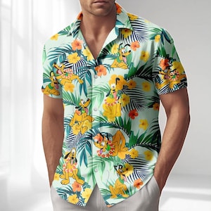 Może przedstawiać: Koszula z krótkim rękawem z powtarzającym się wzorem psa Pluto, żółtych kwiatów i zielonych tropikalnych liści. Koszula ma jasne zielone tło i klasyczny kołnierz.