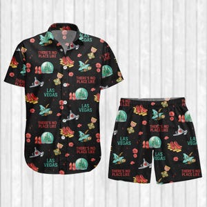 Op de afbeelding: Zwart overhemd met korte mouwen en bijpassende korte broek met een Las Vegas thema. Het patroon bevat showgirl-schoenen, een vliegtuig en een casino. De tekst "There's No Place Like Las Vegas" is ook aanwezig.