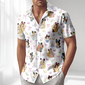Könnte beinhalten: Weißes Button-Down-Hemd mit einem sich wiederholenden Muster aus Cartoon-Prinzessinnen, Schleifen, Herzen und Schlössern. Das kurzärmelige Hemd hat einen klassischen Kragen und eine lockere Passform. Die Prinzessinnen sind in verschiedenen Posen dargestellt.
