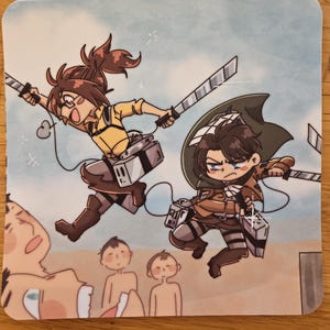 Puede incluir: Posavasos cuadrado con una ilustraci&oacute;n de estilo anime de dos personajes en acci&oacute;n, empu&ntilde;ando espadas. Visten uniformes beiges y marrones con equipo detallado. El fondo es un cielo azul claro.