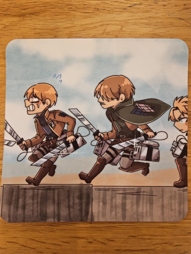 Puede incluir: Posavasos cuadrado con una ilustraci&oacute;n de estilo anime de tres personajes con uniformes marrones y espadas, corriendo. El fondo es un cielo azul claro con un muro gris en primer plano. Los personajes tienen cabello casta&ntilde;o.