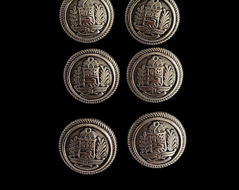 May include: Six gold-toned metal buttons with a raised design of a crest with a lion and foliage. The buttons have a rope-like border.