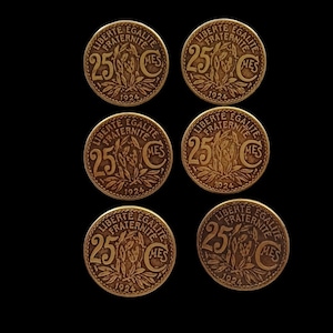 May include: Six gold-colored French 25 centimes coins from 1924. Each coin features the words "Liberte, Egalite, Fraternite" and "25 Centimes" around the edge.