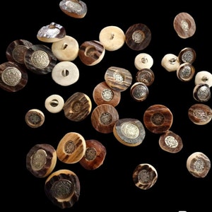 Pode incluir: Conjunto de botões decorativos feitos de materiais naturais, com uma variedade de cores, padrões e texturas. Os botões têm um aspeto rústico e artesanal e são perfeitos para adicionar um toque único à roupa, aos trabalhos manuais e à decoração da casa.