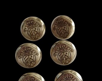 May include: Six gold-toned buttons with a crest design featuring a crown, shield, and stars. The buttons are round and have a slightly raised edge.