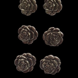 May include: Six silver-toned rose-shaped buttons. The buttons are all the same size and shape, and they have a slightly raised design.
