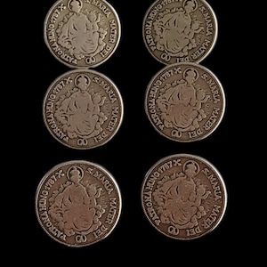 May include: Six antique silver coins with detailed engravings. Each coin features an image of a seated figure and the text "S. MARIA MATER DEI PATRONA HUNG 1787 X". The coins are arranged on a black background.