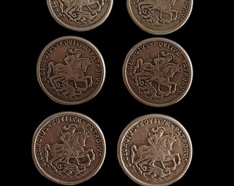 May include: Six silver-coloured coins with a raised image of a knight on horseback slaying a dragon. The coins have the inscription "S.GEORGIVS EQUITVM PATRONVS" around the edge.