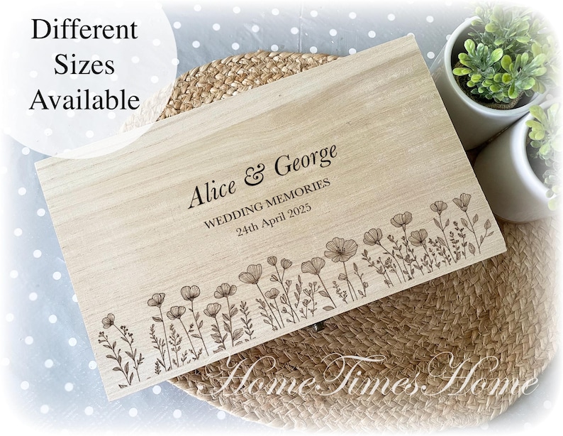 Pu&ograve; includere: Una scatola di legno color chiaro con un motivo floreale e il testo "Alice & George WEDDING MEMORIES 24th April 2025." Sono visibili anche le parole "Diverse misure disponibili". La scatola &egrave; su una superficie tessuta.