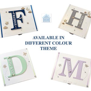 Peut inclure: Quatre bo&icirc;tes &agrave; souvenirs personnalis&eacute;es avec des lettres et des noms. Les bo&icirc;tes sont blanches avec des th&egrave;mes de couleurs diff&eacute;rents : bleu, gris, vert et violet. Le texte "AVAILABLE IN DIFFERENT COLOUR THEME" est affich&eacute;.