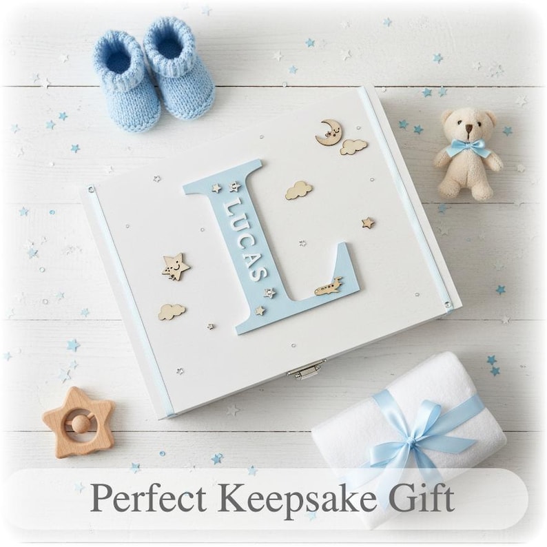 Peut inclure: Coffret souvenir blanc avec un "L" bleu clair et le nom "Lucas". La bo&icirc;te est d&eacute;cor&eacute;e d'&eacute;toiles, de nuages et d'une lune en bois. On y trouve aussi des chaussons bleus pour b&eacute;b&eacute;, un ours en peluche, un hochet en forme d'&eacute;toile et une couverture blanche emball&eacute;e.