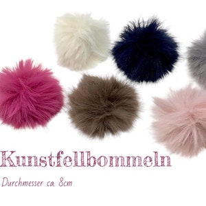 Könnte beinhalten: Sechs Kunstfellbommeln in verschiedenen Farben, darunter rosa, weiß, grau, braun und blau. Jede Bommel hat einen Durchmesser von ca. 8 cm. Kunstfellbommeln. Durchmesser ca 8cm
