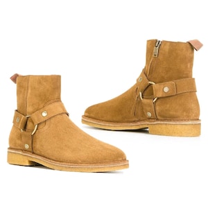 Botines de hombre de ante con arnés, botas de motorista de cuero marrón, detalle de cremallera lateral con anilla.
