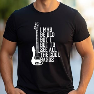 May include: Black t-shirt with a white graphic of a bass guitar and the text "I may be old but I got to see all the cool bands".