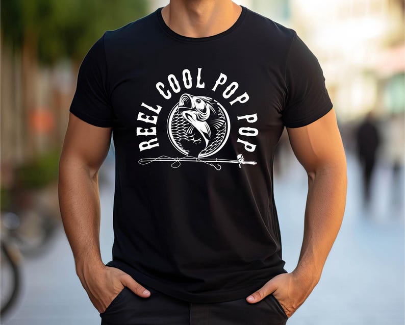 May include: Black t-shirt featuring a white graphic of a fish jumping out of the water with the text "Reel Cool Pop Pop" around it.