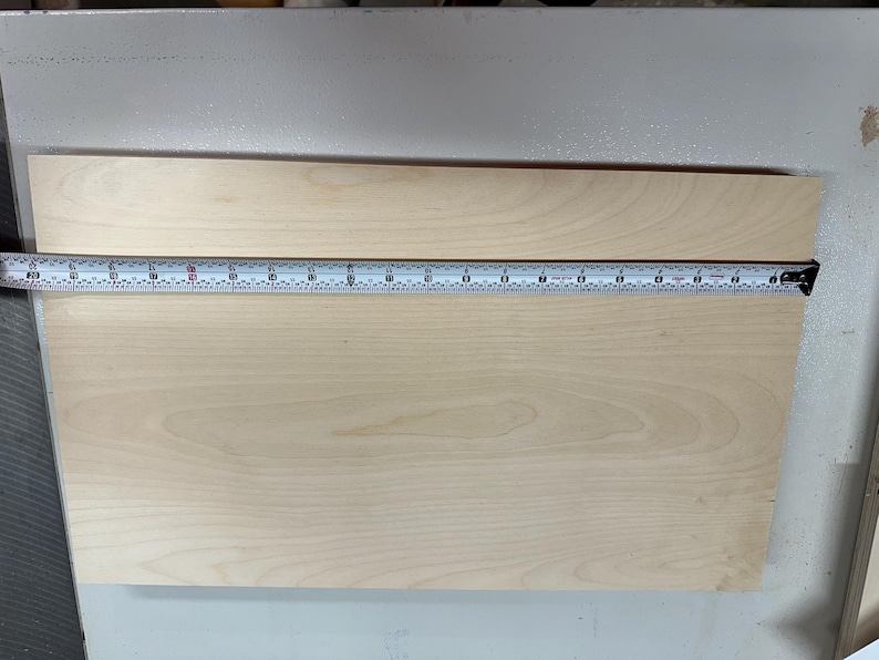 May include: A close-up of a light wood board with a tape measure across the top. The tape measure reads 18 inches.